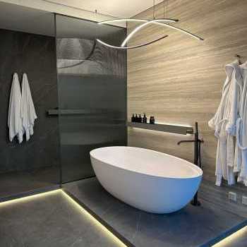 Vasca Antonio Lupi, miscelatore a terra Gessi, accessori Decor Walther, illuminazione Flos